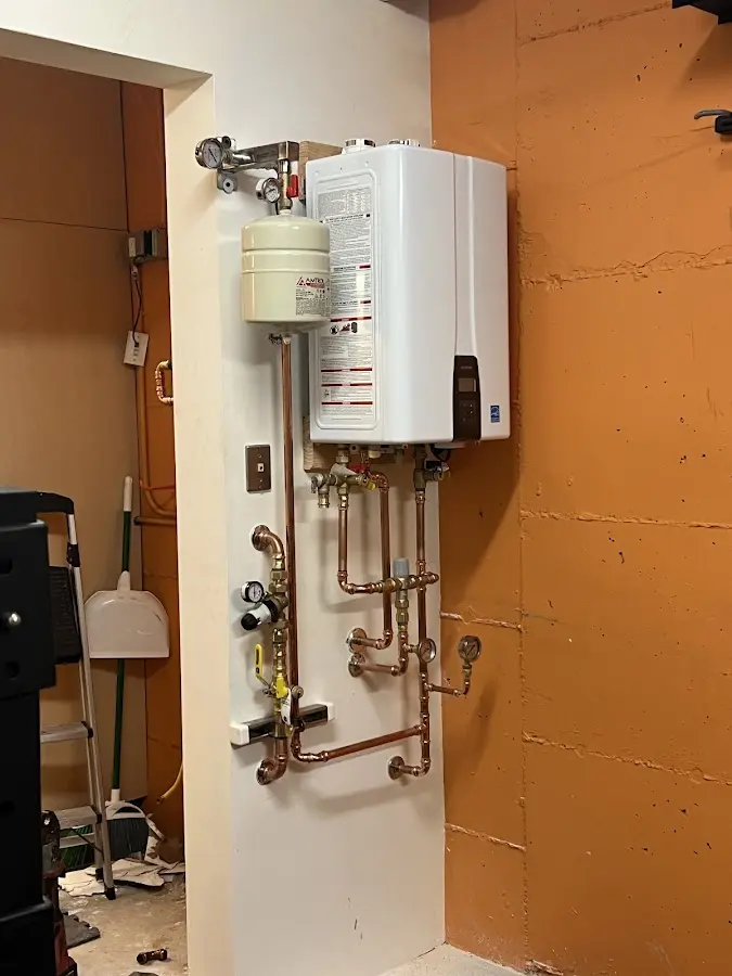 Plumbing technician inspecting water heater connections in Fallon